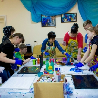 Анна Махмутова (в центре) и ее художники создают картины для будущей выставки Флюид арт