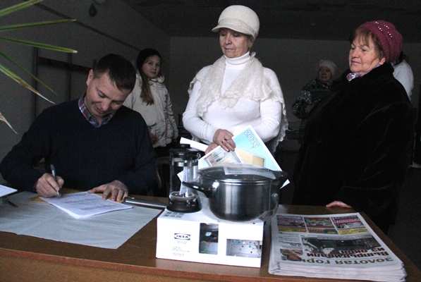 Редактор газеты Павел Шабельников оформляет Ольге Марковой заявку на годовую подписку на «Золотую горку». На заднем плане слева – Алина Бардина, которая помогла провести розыгрыш призов