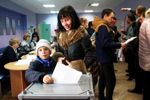 Семья Плехт опускает избирательные бюллетени в урну для голосования на участке № 1171 на втором этаже «Современника». Фото Павла Шабельникова