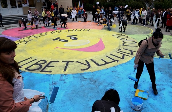 Шесть команд и организаторы конкурса «Цветущий город» перед подведением итогов раскрасили лепестки символа конкурса на асфальте
